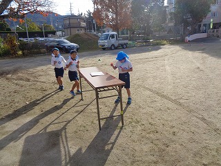 駆け足納会で走った数のテープをはる5歳児