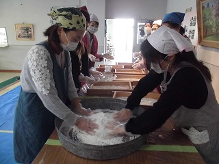 つきたてのお餅を丸める保護者の方たち