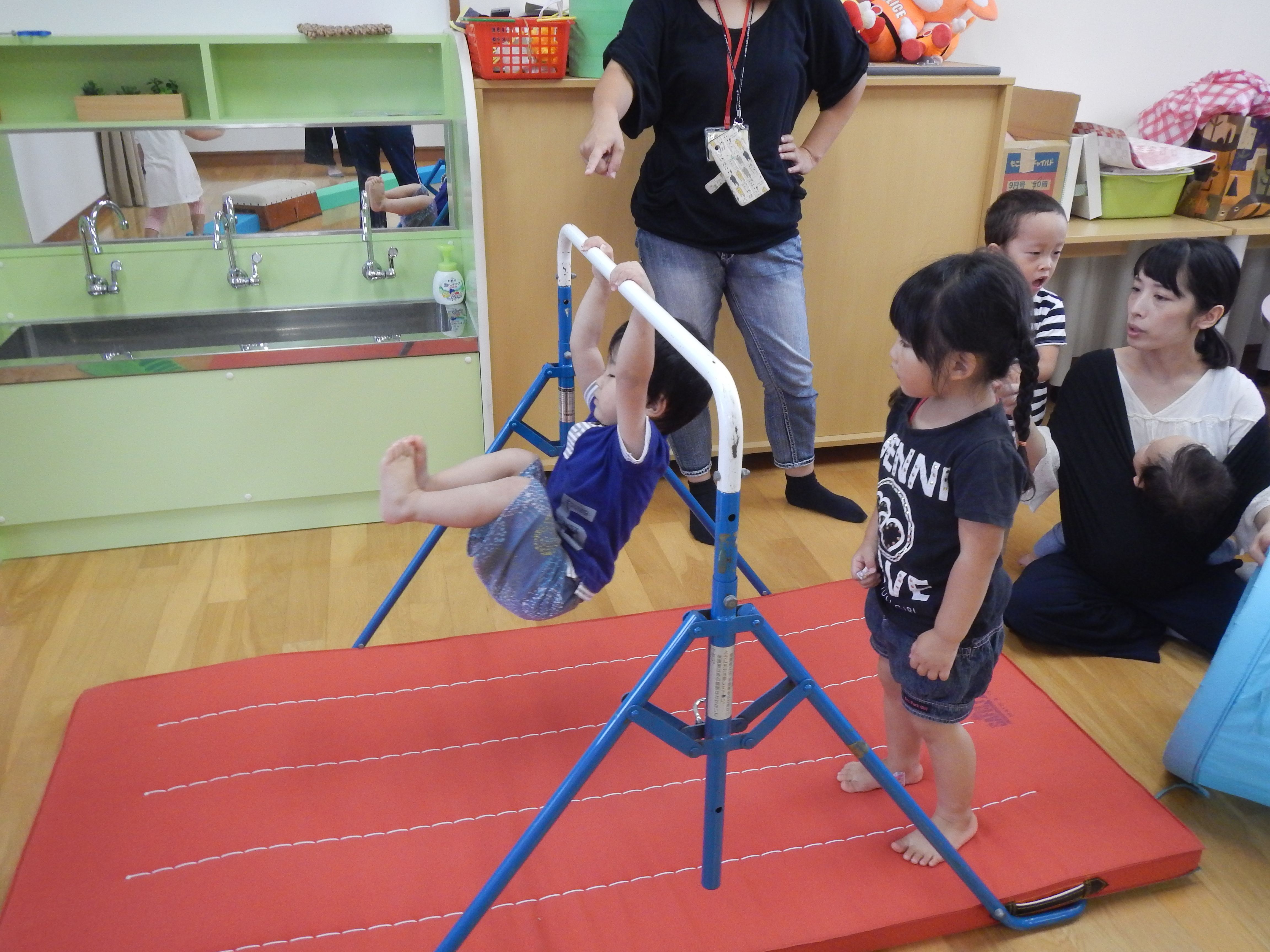 室内用の鉄棒にぶら下がって遊んでいる