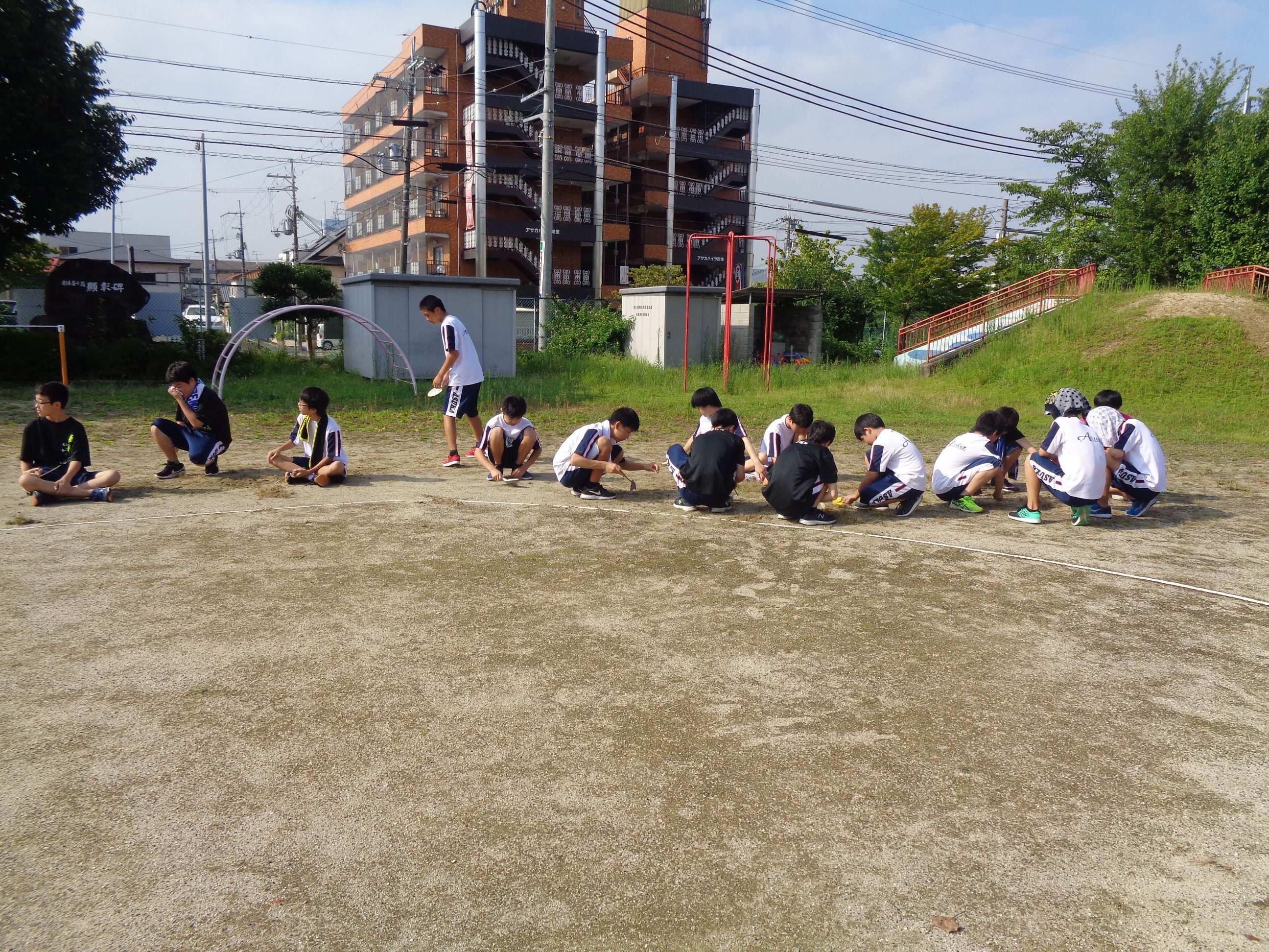 園庭の草彦をする飛鳥中学校の卓球部