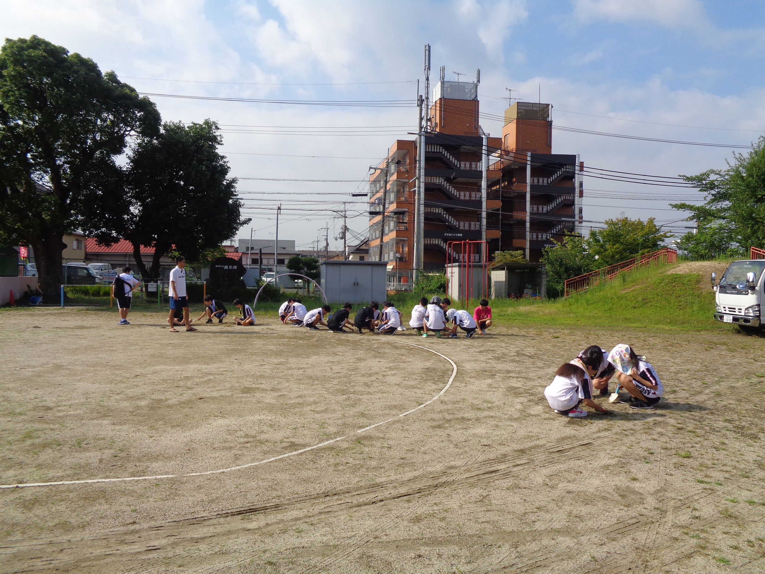 園庭の草引きをする卓球部