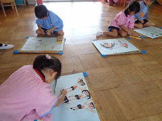 運動会の絵を描く4歳児