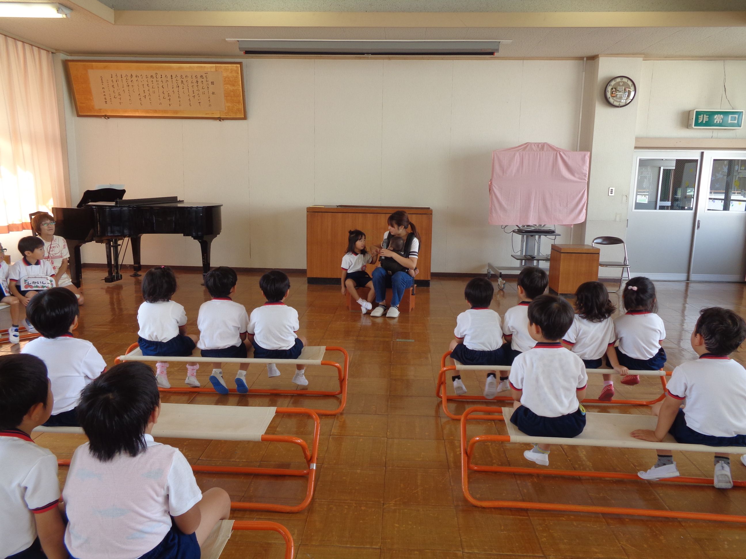 誕生日会でおうちのひとの話を聞く子どもたち