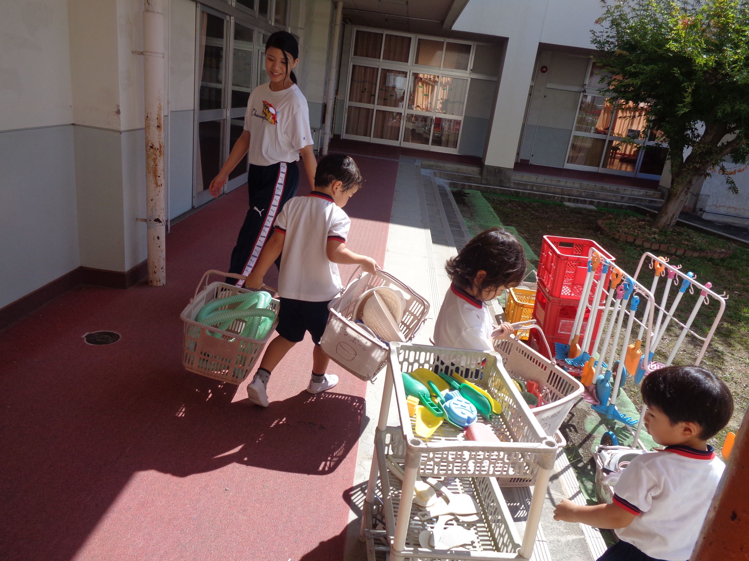 砂場の玩具を運ぶ4歳児