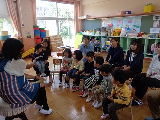園長先生のお話を聞くぽっぽ組の子どもたち