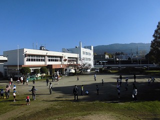 園庭で縄跳びをする園児親子