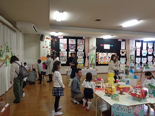 作品展を見学する4歳児親子