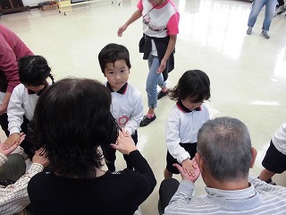 地域の方とわらべうたあそびをする子どもたち