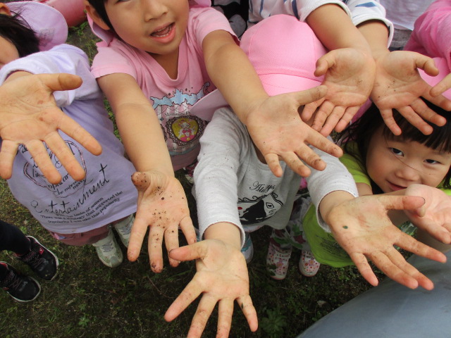 土のついた手のひらを見せる子どもたちの画像2