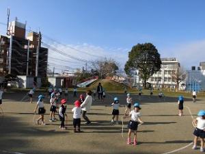 園庭で縄跳びをする幼稚園児と極楽坊保育園児