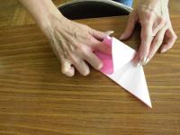折り紙の三角の袋になっているところに指を入れて押し広げようとしているところ