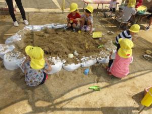 3歳児が保育室前の砂場で遊んでいる様子