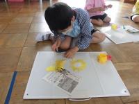 黄色の色画用紙で花びらを作る年長男児