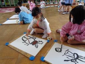 クワガタムシの絵を描く4歳女児