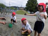 泥んこ遊びをする4歳児