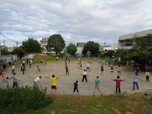 園庭でラジオ体操をする地域の人たち