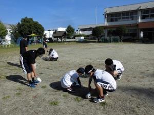 園庭の草ぬきをする卓球部の中学生