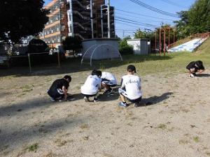 幼稚園の園庭の草ぬきをする中学校の卓球部員