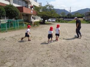 担任とサッカーをする4歳児