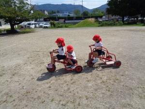 友だちと三輪車で遊ぶ4歳児