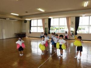 リズム室でポンポンを持って踊る4歳児