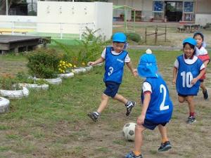 サッカーゲームでボールを追いかける5歳児