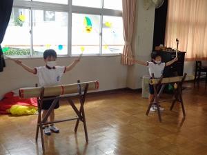 リズム室で竹太鼓をたたく5歳児