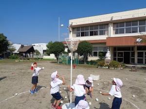 白の玉入れをする4歳児