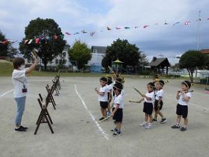 竹太鼓のたたき方の話を担任から聞く5歳児