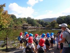 池の向こうに見える浮見堂を眺める子どもたち