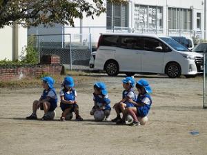 サッカーボールの上に座る5歳児青チーム