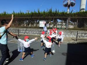 地域の方の畑に行く途中で、手をあげて道路を渡る4歳児