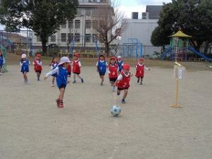 サッカー教室でボールを追いかける4歳児