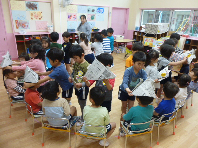 5歳児が3歳児に手作りのカブトをプレゼントしました