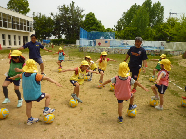 5歳児サッカースクール　合図を聞いてボールをとめ、ポーズをしています