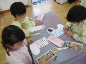 画用紙を切って、模様を描いています。