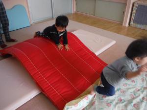 0歳児　マットによじ登っています