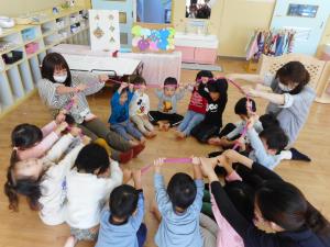 2歳児　ゴムチューブを持ってみんなで輪になっています