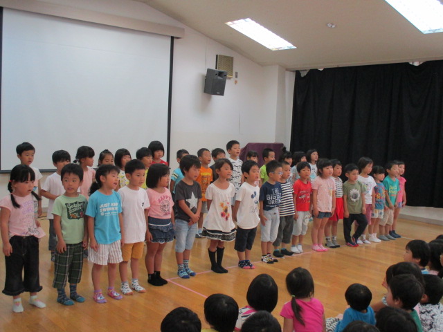 みんなの前で歌を歌う5歳児