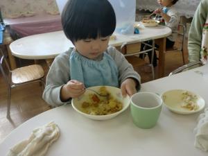 1歳児　スプーンを使って食べています。