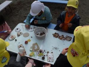 4歳児　ドングリや木の実のケーキづくりをしています。