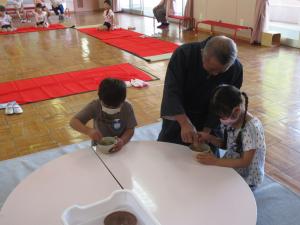 お茶の点て方を教わっている男の子と女の子