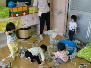 1歳児が新聞紙で遊んでいます。
