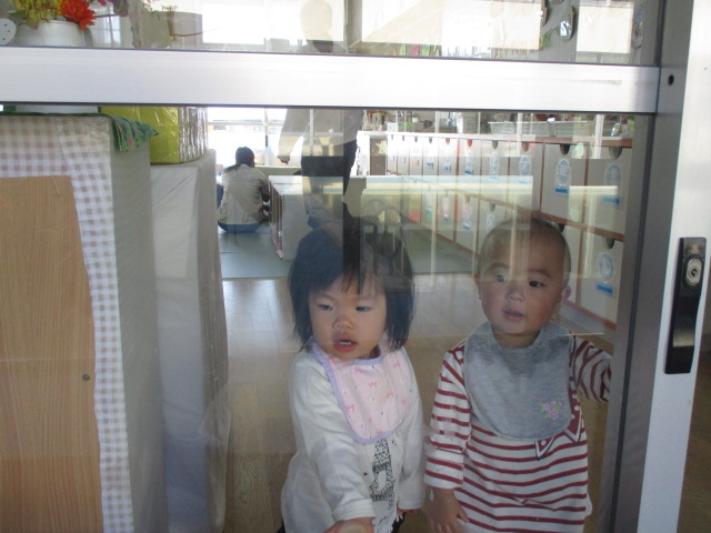 お部屋から焚き火のようすををみる0才児
