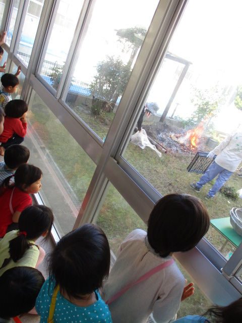 廊下から焼き芋のようすを見る2歳児