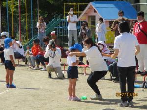 メダルを抱えてもらっている5歳児
