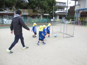 男の子とコーチが試合をしています