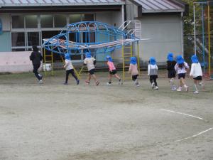 園庭を走っている5歳児
