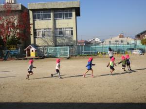 園庭を走っている4歳児