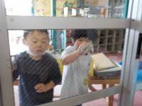 ３歳児　窓ふきをしています